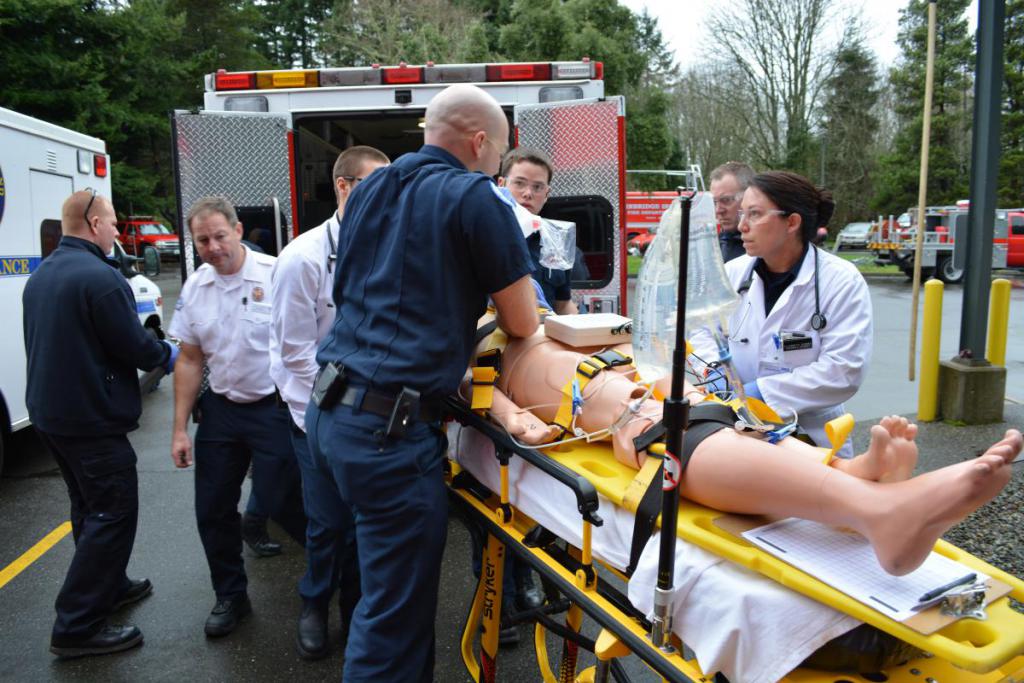 Students prepare and load a patient into the vehicle.